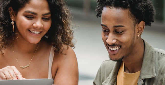 Two people reading content in a computer.